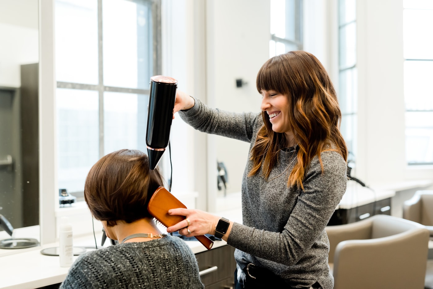 A stylist finishing a client&rsquo;s hair at Lash Out